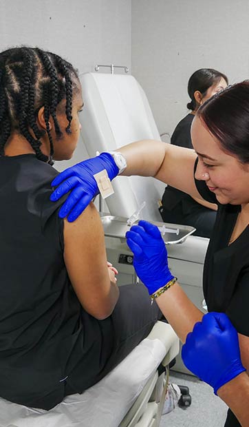 Medical assisting students practice administering vaccines