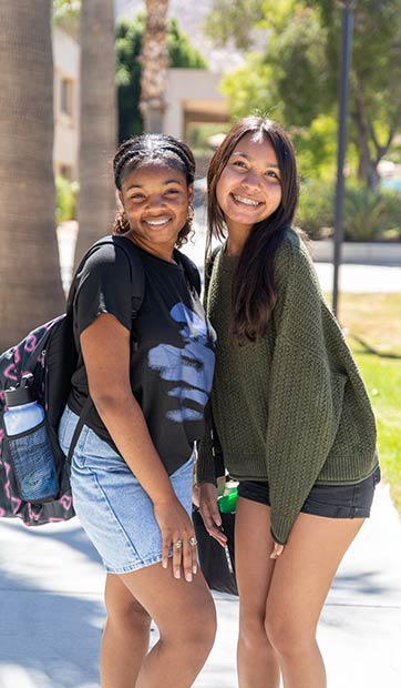 Two students pose happily in sunny Coudures plaza